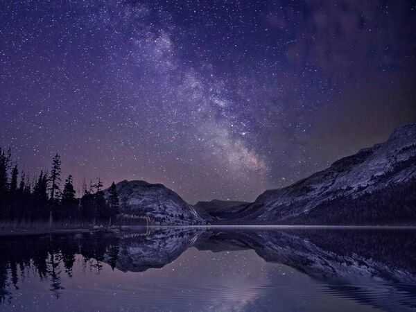Cielo nocturno con estrellas sobre un paisaje oscuro